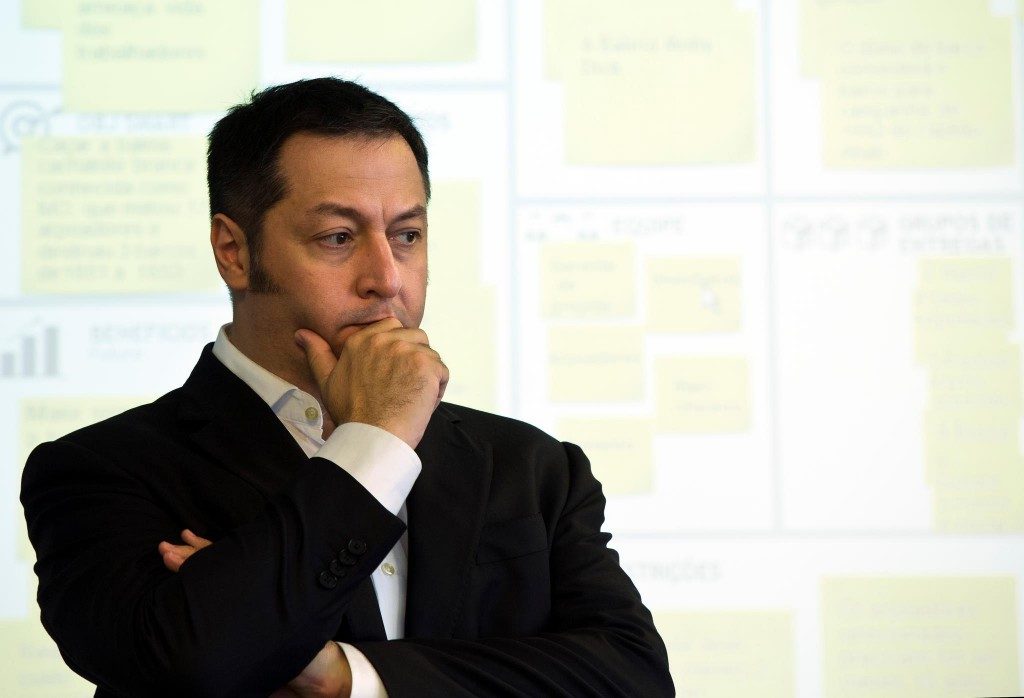 José Finocchio Junior diante de um canvas coberto de post-its.